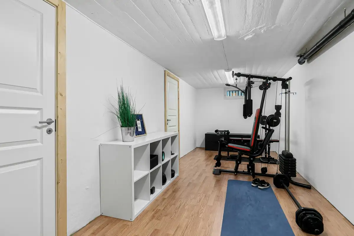 マットとトレーニング器具が置かれた、小さく落ち着いた部屋